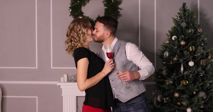 Christmas portrait of lovers with glasses. Guy gives the girl a gift. The woman returned the gift. Refused the guy. Unsuccessful gift to his beloved. Background of Christmas tree and wreath Video 4k