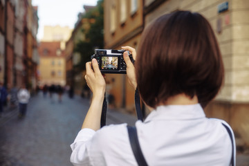 The girl in the black hat shooting in an old european town.