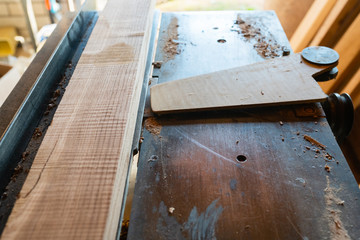 Working woodworking machine with cutting board on it closeup. Selective focus. Manual wood processing concept.