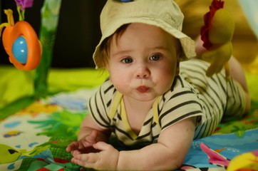 6 month old baby European wearing a safari hat on a jungle play mat - portrait