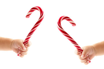 Traditional striped candy canes in kids' hands isolated on white background