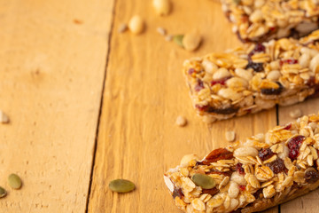 granola bars and nuts on a wooden background with space for design, horizontal photo, diet, proper nutrition