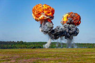 Giant outdoors explosion with fire and black smoke. military jeep vehicles during airshow at...
