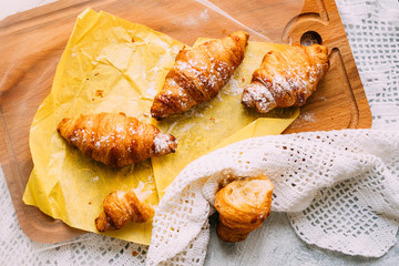 Fresh croisants on the wooden board with white towel
