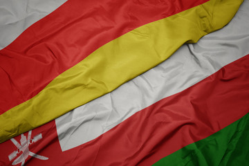 waving colorful flag of oman and national flag of south ossetia.