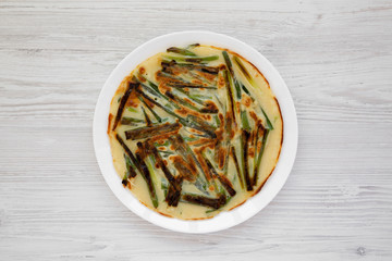 Homemade korean Pajeon scallion pancake on a white plate on a white wooden table, view from above. Asian food. Flat lay, top view, overhead.