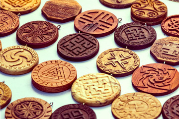 Wooden household items with ancient Slavic Nordic handmade symbols crests, runes, hats.