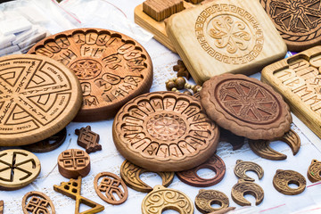 Wooden household items with ancient Slavic Nordic handmade symbols crests, runes, hats.