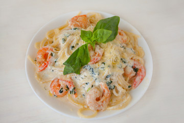 delicious delicious spaghetti with shrimps and basil on  plate