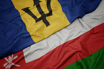 waving colorful flag of oman and national flag of barbados.