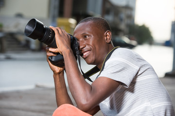 close-up of man with camera, smiling.
