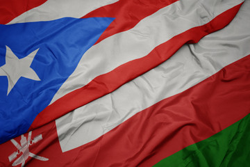 waving colorful flag of oman and national flag of puerto rico.