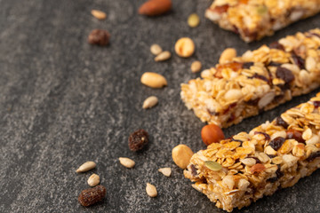 granola bars with nuts on a dark background with space for design, horizontal photo, diet, proper nutrition