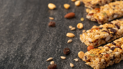 granola bars with nuts on a dark background with space for design, horizontal photo, diet, proper nutrition