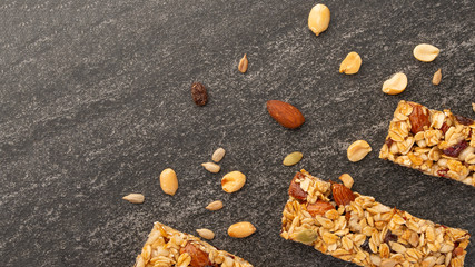 Fototapeta premium granola bars with nuts on a dark background with space for design, horizontal photo, diet, proper nutrition