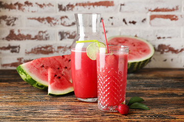 Glass and bottle of fresh watermelon juice on table