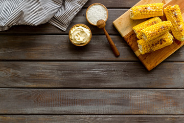 Fried corn on board with salt and butter on wooden background top view mockup