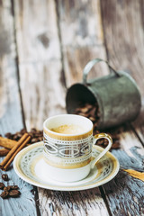 Tasse de café en porcelaine ancienne pot en métal cannelle et grains de café sur une table en bois vintage	