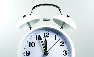 Close up White Alarm clock face beginning of time 11.56 on white background, Copy space for your text, Time concept..
