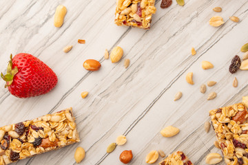 granola bars with nuts and strawberries on a light background with space for design, horizontal photo, diet, proper nutrition