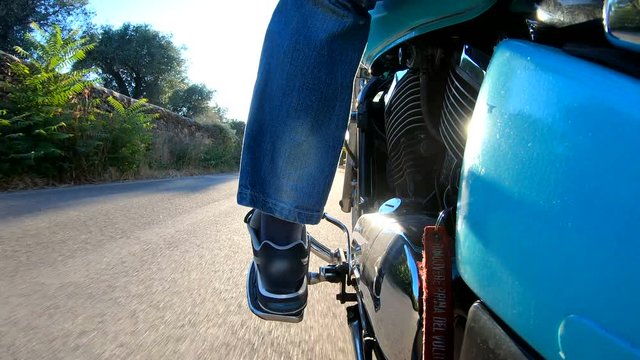 Motorcycle ride on a winding coastal road seen from behind. Sardinia, Italy