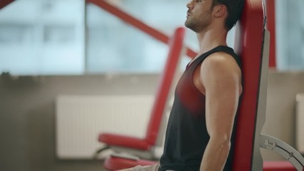 Strong man weightlifter having exercises with dumbbell in sport club.