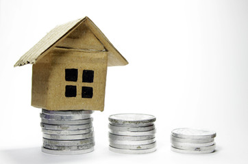 coin and miniature house on white background