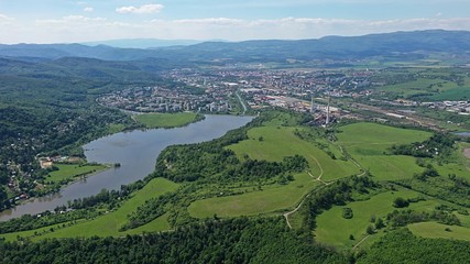 Fototapeta na wymiar Aerial view of Motova river dam built on Slatina river, forest and meadows in front, Zvolen city and surrounding hills in background. 