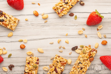 granola bars with nuts and strawberries on a light background with space for design, horizontal photo, diet, proper nutrition