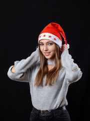 Beautiful girl posing on the black background in New Year outfit.