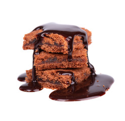Slices of brownie, isolated on white background, covered with dark chocolate syrop.