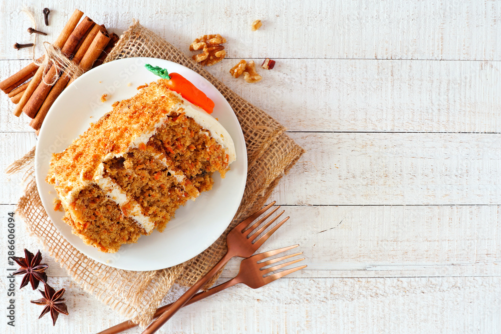 Aufkleber slice of homemade carrot cake with cream cheese frosting. above view over a rustic white wood backgr