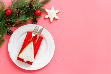 Table setting for new year with pine, decorations, plate and tableware pink background top view copyspace