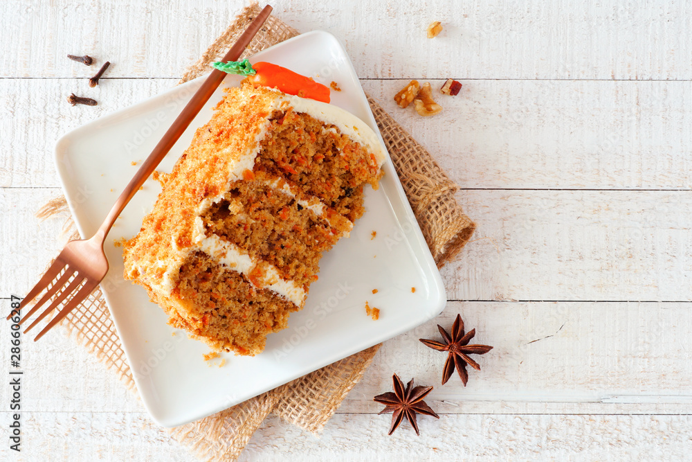 Aufkleber slice of homemade carrot cake with cream cheese frosting on a plate. top view table scene over a rus