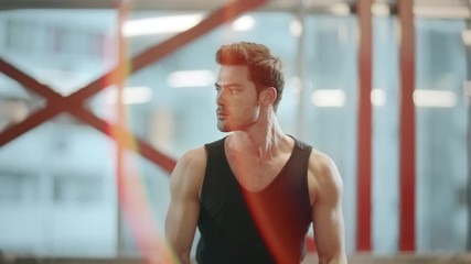 Strong fitness trainer doing power lifting exercises in sport center.