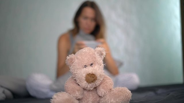 Attractive Brunette In Bed With A Phone In Her Hands And Teddy Bear Favorite Toy Soothing Trust Secrets Close Native Social Network Internet Correspondence Pillow Loneliness Loss Relationship Concept