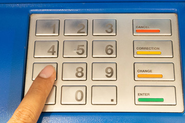 finance, money, bank and people concept - close up of hand entering pin code at atm machine,closeup of hand pressing the PIN security number ATM keyboard.