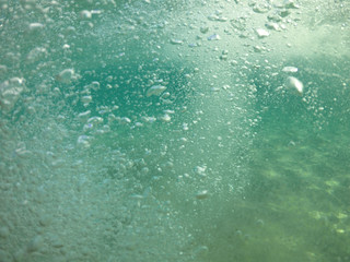 Underwater air bubbles as seen at sea rising at surface level