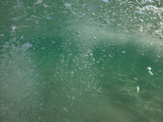 Underwater air bubbles as seen at sea rising at surface level