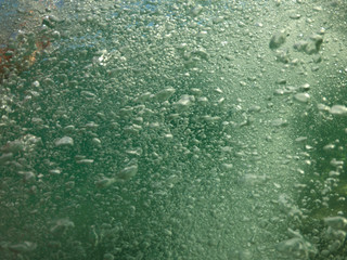Underwater air bubbles as seen at sea rising at surface level