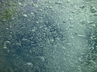 Underwater air bubbles as seen at sea rising at surface level