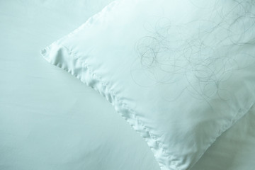 Soft pillow with fallen down hair,Hair loss with Pillow on the bed, background.with copy space.