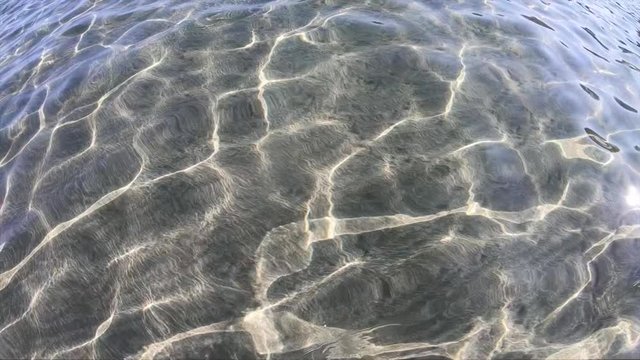 Slow motion of clear sea water in tranquil shallow sandy beach