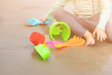 Adorable toddler girl playing with beach toys on sand beach,cute little girl play with sand on beach,Baby girl sitting on a beach.