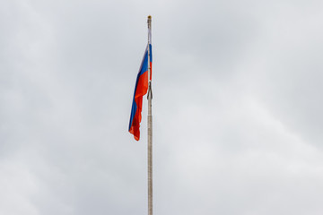 Waving flag of Russia against gloomy cloudy sky