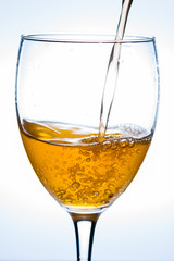 Pouring champagne into a wine glass.