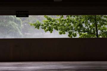 A view of rainy weather from a parking garage.