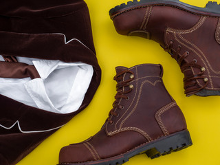 Flat lay, top view, men fashion casual clothing set isolated on yellow background include brown boot, suit and white shirt.
