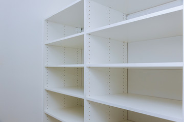 Interior of white plastic cabinet or clothing with many empty shelves with installation.