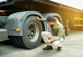 Fototapeta na wymiar truck driver inspecting safety check of a truck tires.